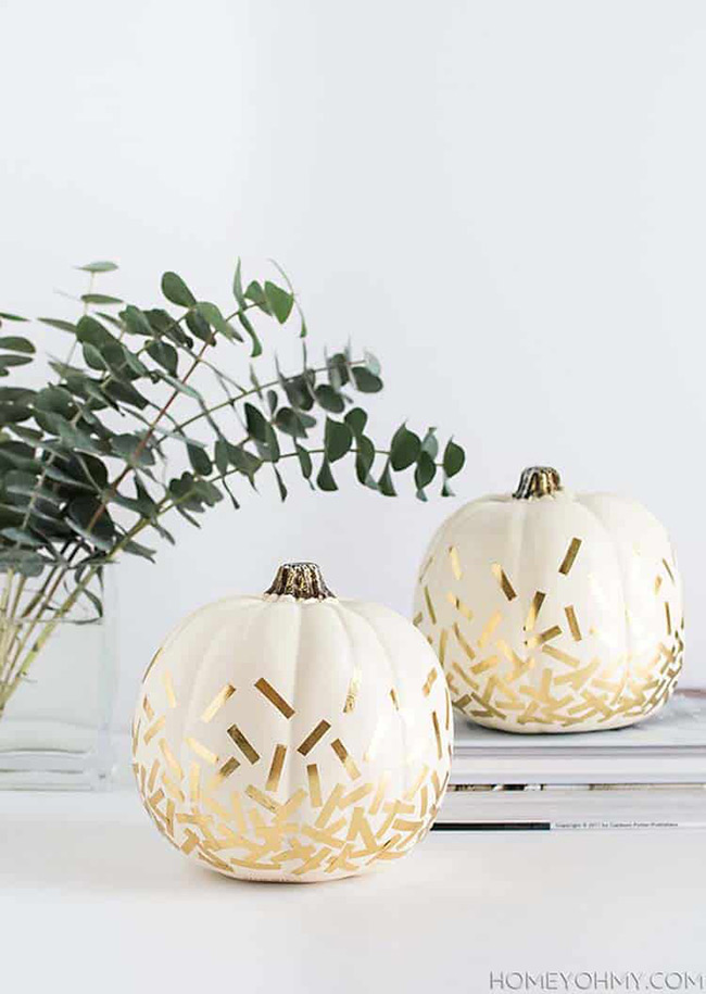 What a fun DIY project! Sticking little pieces of gold foil onto a white pumpkin makes it look like it's covered in fancy confetti. It's a very chic and modern way to decorate for fall.