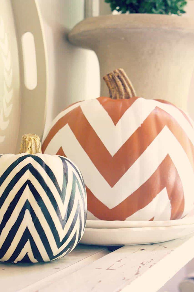 Painting bold chevron stripes on pumpkins turns them into cool, graphic art pieces. Using a classic white pumpkin as the base makes the orange and black colors really pop.