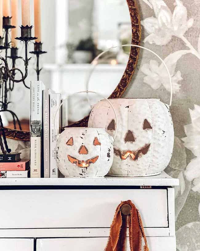 This is a cute idea for the shelf, using two small, white metal jack-o'-lanterns that are lit from inside. The aged, distressed look gives them a nice vintage feel for Halloween decor.