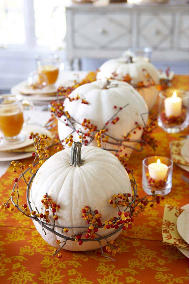 For a truly elegant fall dinner party, place a large white pumpkin in the center of the table. Wrapping a simple wreath of colorful berries around the base adds the perfect festive touch without a lot of effort.