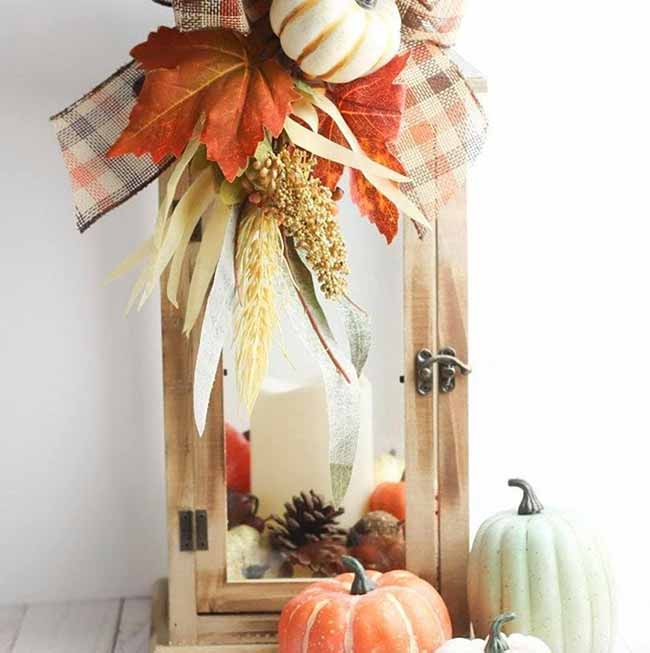 This light wood lantern is decorated perfectly with a big plaid bow, white wheat stalks, and beautiful red leaves on top. The little pumpkins and pinecones inside and outside make it a cheerful piece of autumn decor.