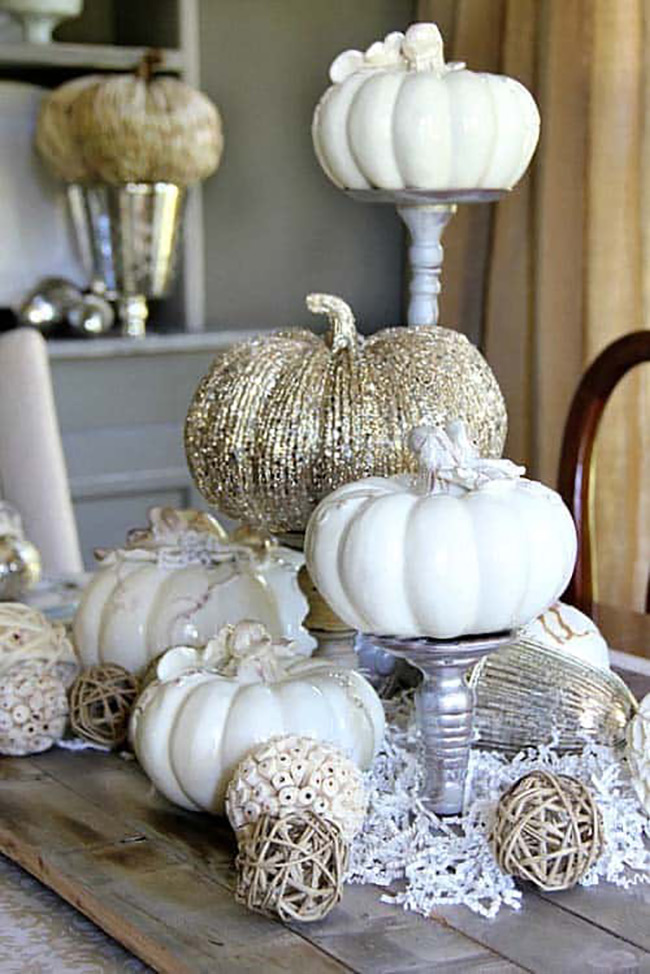 Really love how they used white pumpkins, some shiny and one with lots of gold sparkle, all standing on pretty silver pedestals. It’s a very elegant way to decorate a table for the autumn season.