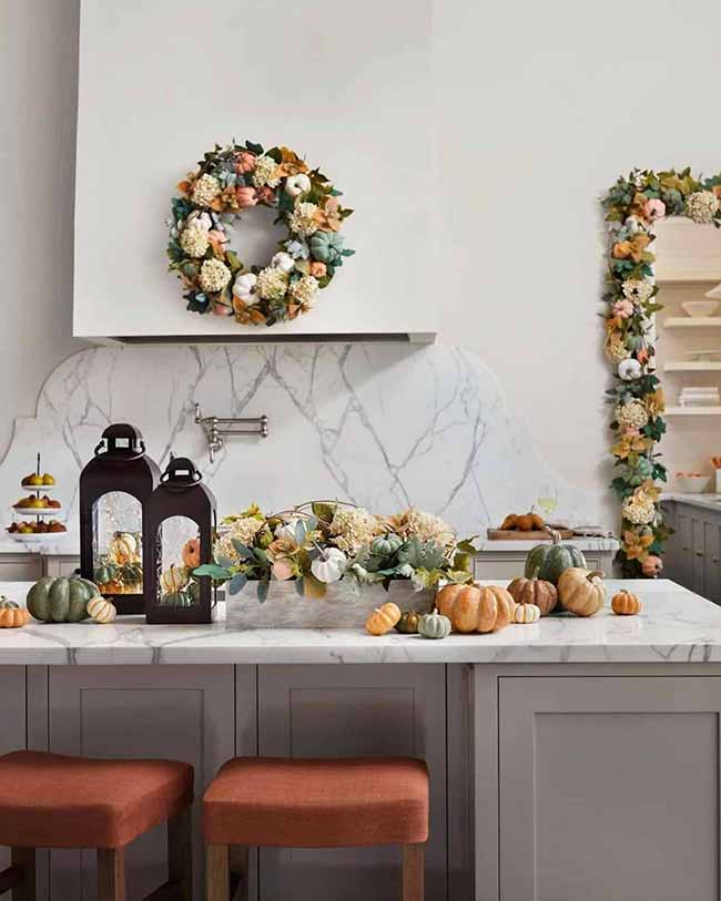 These two black lanterns are a great contrast against the white marble kitchen countertop, surrounded by pumpkins and a gorgeous wreath in soft greens and oranges. The whole kitchen feels upscale and ready for the harvest season.