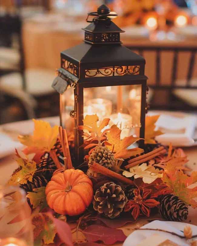 This black metal lantern looks perfect as a table centerpiece, glowing with candles inside. They surrounded it with pinecones, whole cinnamon sticks, star anise, and beautiful maple leaves to bring in all the best sights and scents of the season.