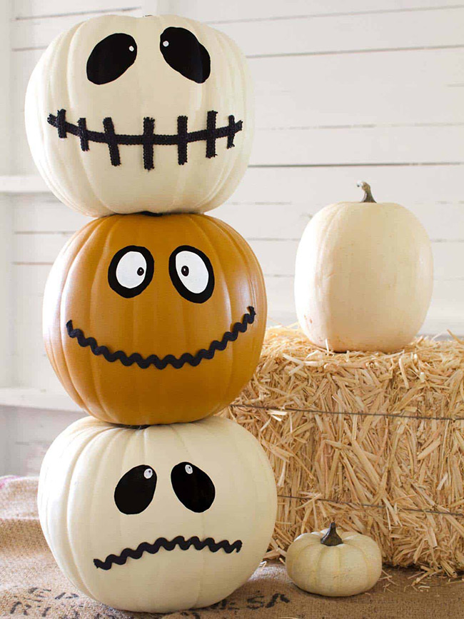 These stacked pumpkins are so fun and friendly! The top and bottom white pumpkin faces are a bit goofy and look great with the orange one in the middle. It's a silly, cute way to use a white pumpkin for a Halloween decoration.
