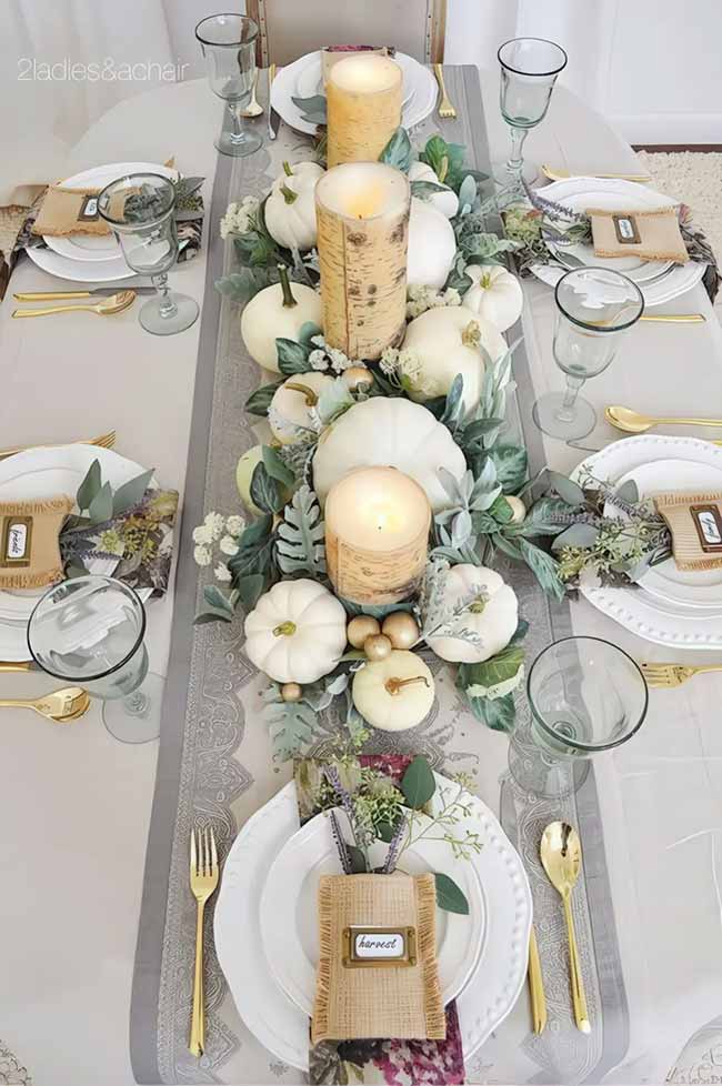This fall tablescape looks so elegant, filled with white pumpkins and greenery. The gold silverware and birch-covered candles make the whole scene look extra classy, perfect for a formal fall dinner party.