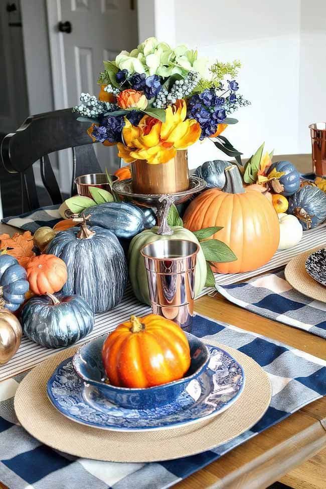 I never would have thought to use blue for fall decor, but it looks amazing here! The blue and orange pumpkins with the table runner and flowers create such a bright and cheerful fall table.