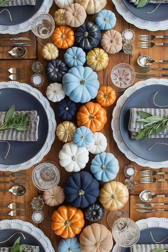 I love how this table runner uses pumpkins in blue, orange, and white. It's a really modern and fun way to decorate for a fall party.