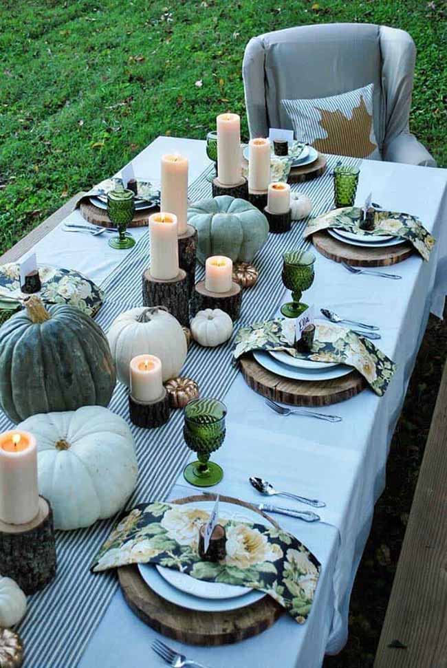 This outdoor table setting feels so calm and elegant with its muted green pumpkins and floral napkins. The wood chargers and log candle holders add a perfect rustic touch to the sophisticated look.
