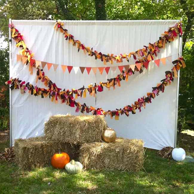 A DIY photo booth is a guaranteed way to make a fall party more fun. The hay bales and fabric garlands create the perfect backdrop for autumn pictures.