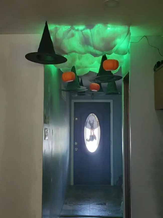 This hallway looks so spooky with the green light shining on the ceiling. I love the floating witch hats, and putting little pumpkins on top of them is a really funny idea.
