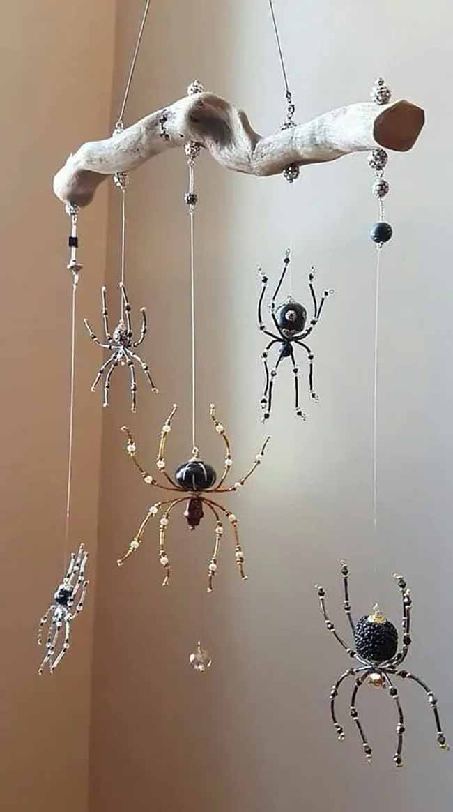 What a fancy Halloween decoration! These spiders are made of beads and hanging from a stick. It's like a pretty, but creepy, mobile for the ceiling.