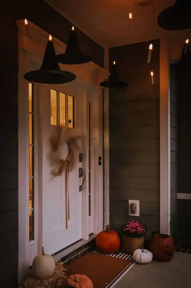 Floating witch hats and floating candles are the best combination for a magical Halloween porch. It looks like it's straight out of Hogwarts. This ceiling decor makes the front door look so inviting.