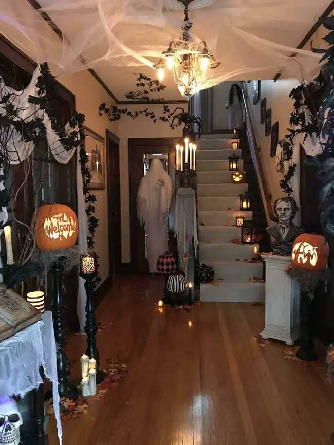 This person turned their whole house into a haunted mansion! The spiderwebs on the ceiling and chandelier look amazing with the ghosts on the stairs.