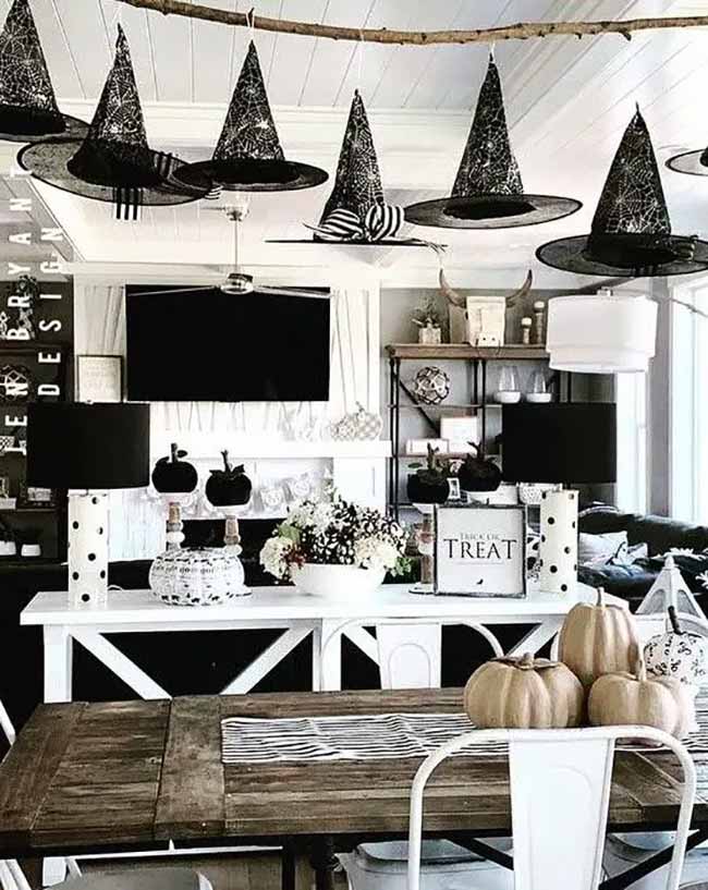 I love how these witch hats are hanging from the ceiling right over the table. It looks like they are having their own Halloween party. This is a great idea for a dining room.