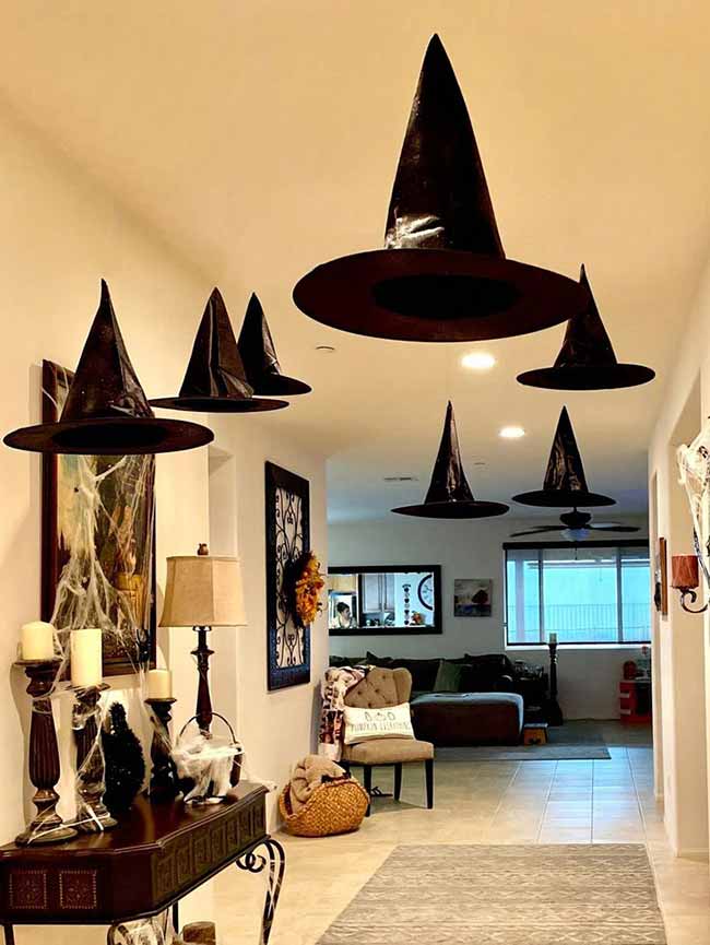 Floating witch hats are the perfect decoration for a long hallway. This is such a simple way to make the whole ceiling look magical for Halloween.