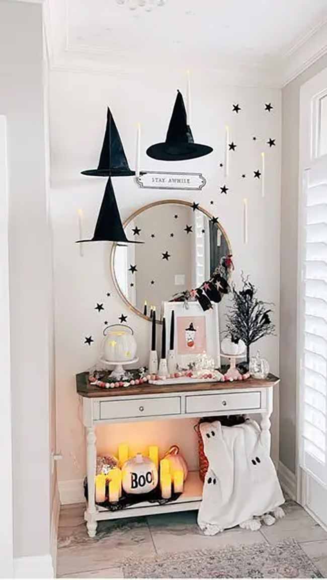 This is a very cute Halloween setup. Hanging the witch hats and candles on the wall draws your eye up and makes the whole space feel festive.