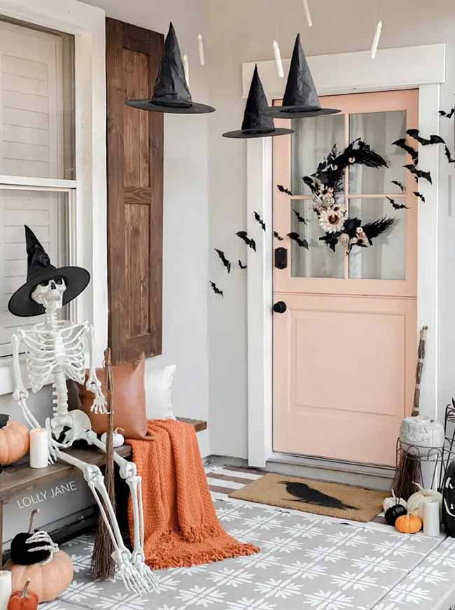 This porch is so cute! I love the pink door with all the spooky decorations. Hanging witch hats and floating candles from the ceiling makes it look so magical.