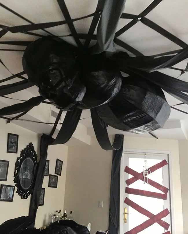 That is one giant, scary spider on the ceiling! It looks like it was made from streamers and trash bags. I would be so scared to walk under that.