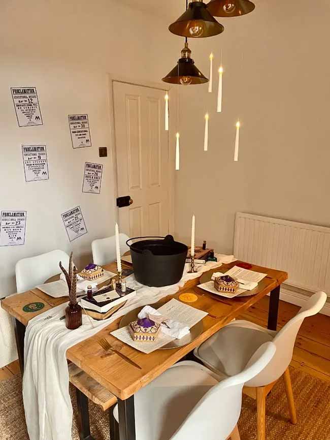 This is the perfect Harry Potter dinner. Floating candles are hanging from the ceiling lights. They even have a cauldron centerpiece.