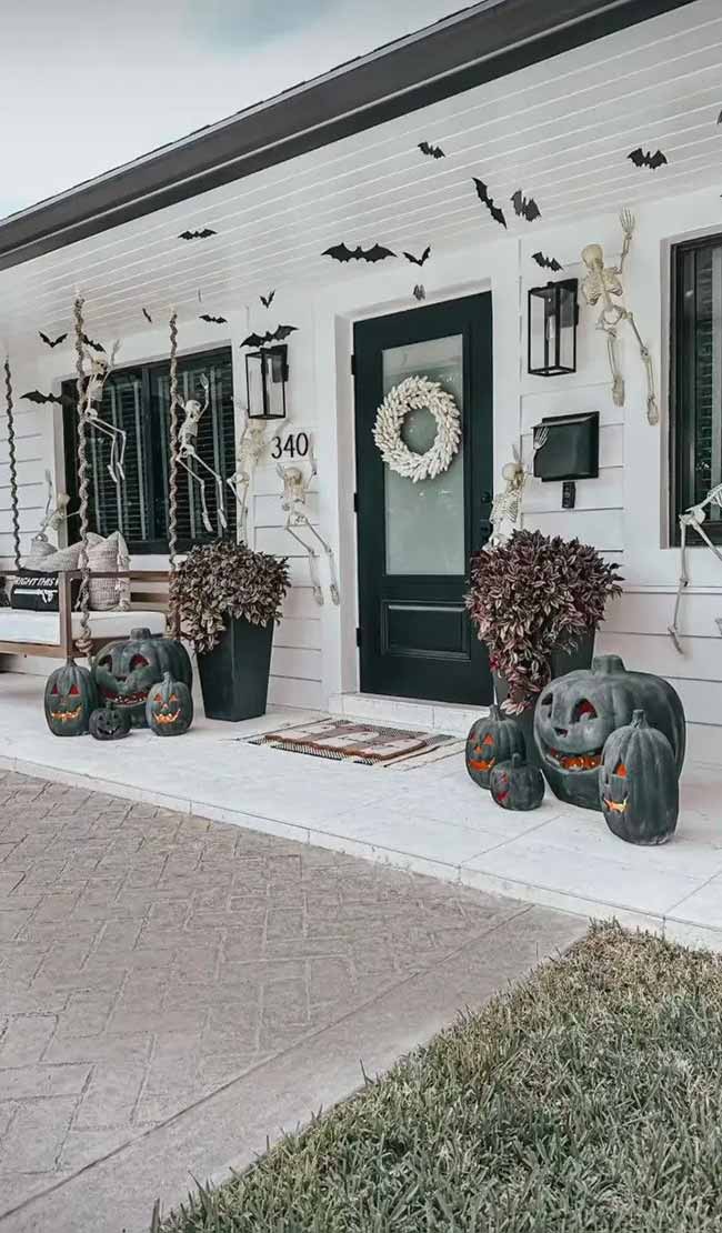 This is such a cool spooky porch. The bats on the ceiling look great with the climbing skeletons and dark pumpkins.