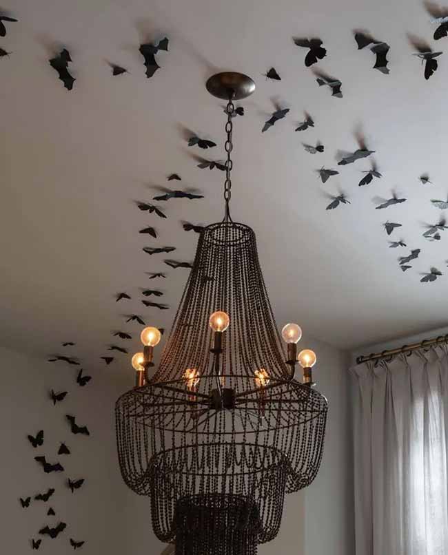 Putting all the bats on the ceiling like they are flying away from the chandelier is a really smart Halloween idea.