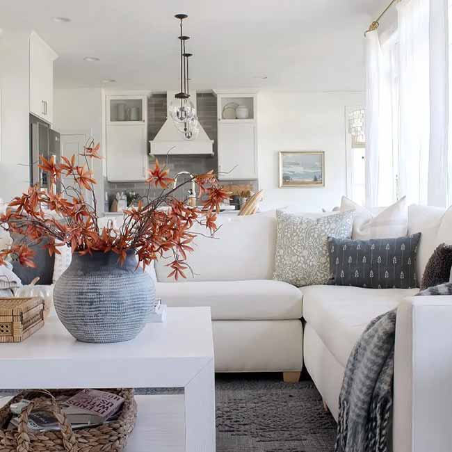 The bright orange leaves in the big gray vase are the perfect pop of color against the white couch and kitchen. I like how they kept the decor simple and airy but still brought in the fall mood.