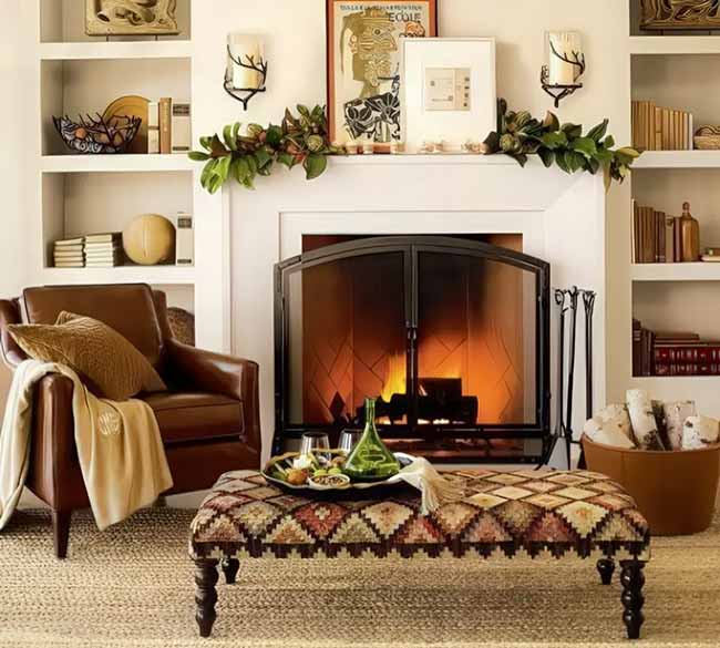 That rich brown leather chair is the perfect spot for reading next to a fire. The patterned ottoman as a coffee table is unique and brings in a lot of color and texture. The simple green garland over the mantel is an elegant, subtle fall decoration.