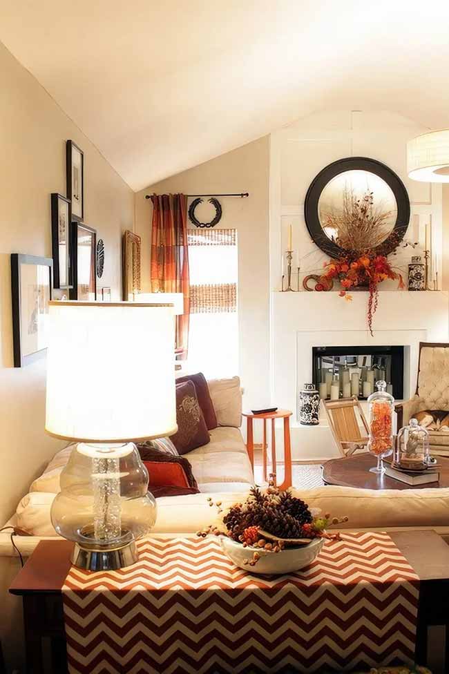 This room uses simple colors but has a lot of rich fall texture. The red chevron table runner and the bowl of pinecones on the coffee table are bright and fun. I like the big mirror and the wreath on the fireplace in the background.