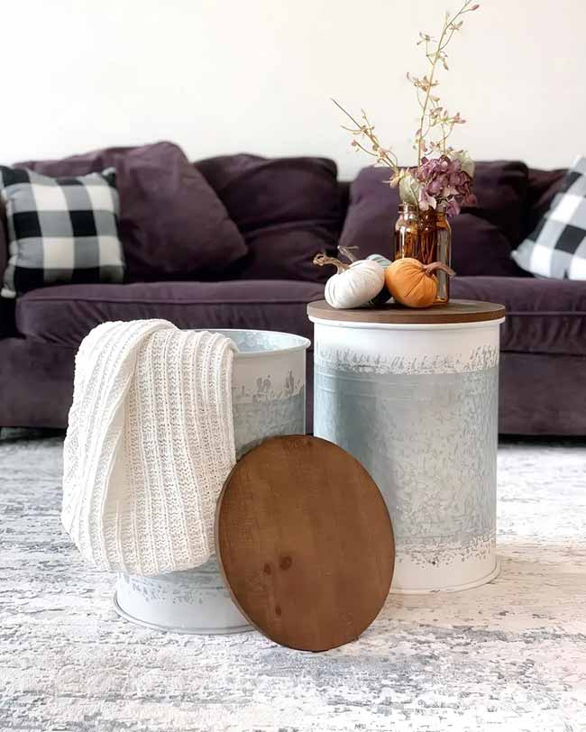 The dark purple couch makes a bold statement, but the white and black pillows keep it simple. They used two galvanized metal buckets for side tables, which is a clever rustic idea. The little white and orange pumpkins on the top add a small, sweet touch of fall.