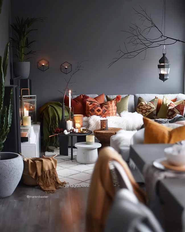 The dark walls and many candles make this room super moody and cozy. The rich orange and green pillows bring in the fall colors in a cool way. It looks like a perfect spot to curl up on a chilly night.