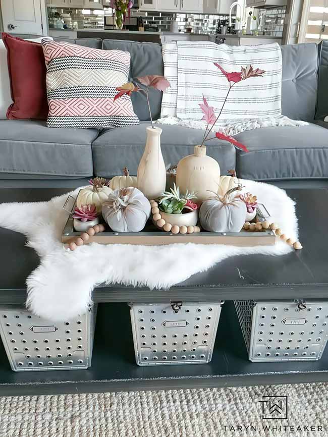 I love this neutral fall style! The gray and white pumpkins on the tray are very chic. Placing the whole tray on a fluffy white rug adds so much texture to the coffee table.