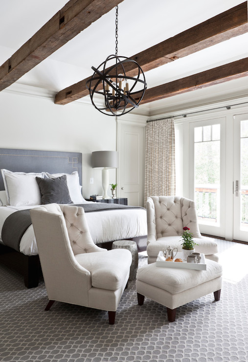 Look at those beautiful high-backed tufted chairs! They form a sophisticated sitting area right in front of the bed, complete with an ottoman for serving breakfast.