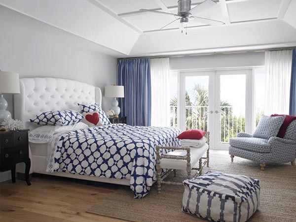 Blue and white patterns bring so much life to this sunny master suite! The lovely sitting area by the balcony doors includes a patterned accent chair and a large, cozy striped pouf, making it a fun and comfortable corner to relax and enjoy the ocean breeze.