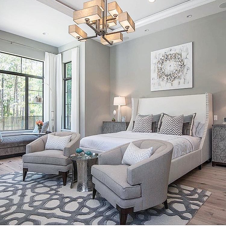 Neutral colors look so chic and inviting in this light-filled room. The main sitting area features two lovely curved gray armchairs placed on a dramatic abstract rug. Plus, the clever window bench provides another casual spot to sit and look at the outdoors.