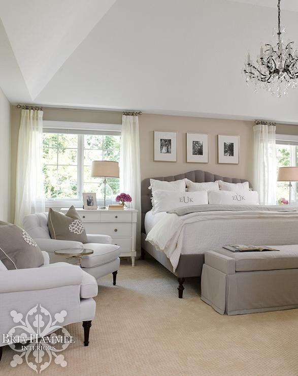 Soft neutrals and lots of natural light make this master bedroom feel incredibly restful. The main sitting area consists of two plush light gray club chairs next to the window, and a storage bench at the foot of the bed provides extra, functional seating—a brilliant idea for tidy rooms.