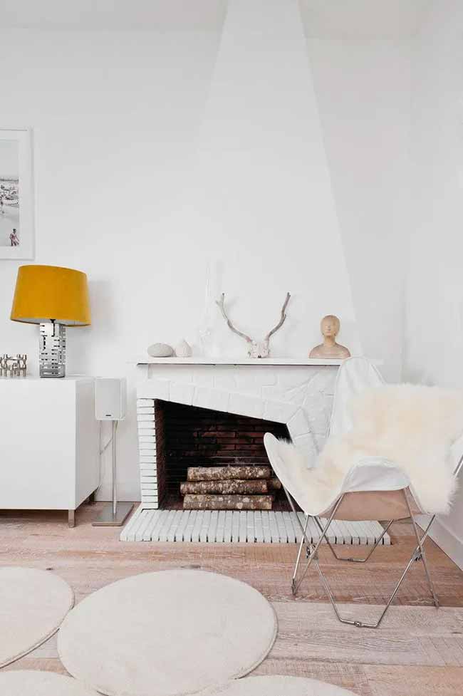 Bright Fireplace Corner. The white brick fireplace has a cool, modern slant to it. I like the pop of yellow from the lampshade next to the natural antler and sheepskin on the chair.