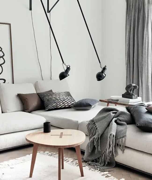 Modern Living Room. This sofa looks so soft and comfortable with the fuzzy gray blanket draped over it. The clean lines of the furniture and the dark swing lamps feel very modern and cool.