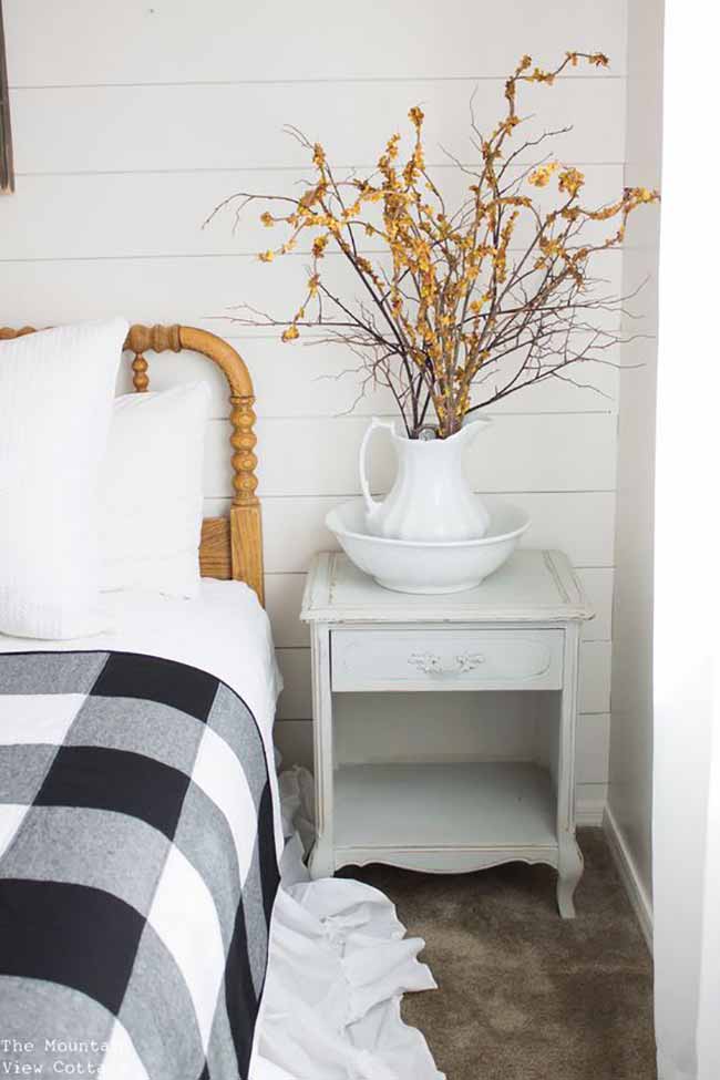 Buffalo Check Bedding. The chunky black and white plaid blanket adds a fun, cozy feeling to this light bedroom. The antique white nightstand with the bowl and pitcher full of yellow branches is a sweet, rustic touch.