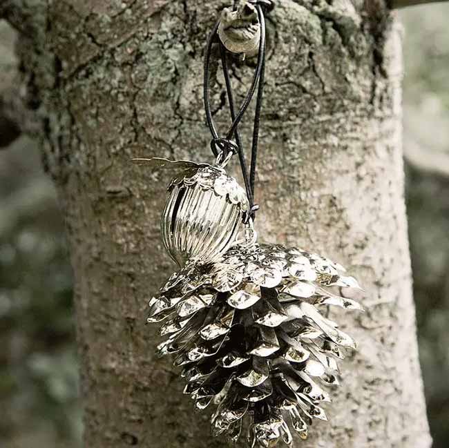 Metal Pinecone Ornament. This shiny silver pinecone ornament hanging from the tree is a cool, unexpected twist on a natural item. It catches the light well and makes a simple, special decoration.