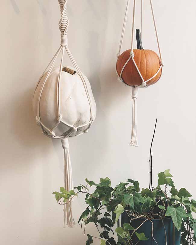 Hanging Pumpkins. I love this fun, bohemian way to display white and orange pumpkins in macrame hangers. The different colors and textures of the pumpkins look great hanging high up. It’s a very creative take on fall decorations.
