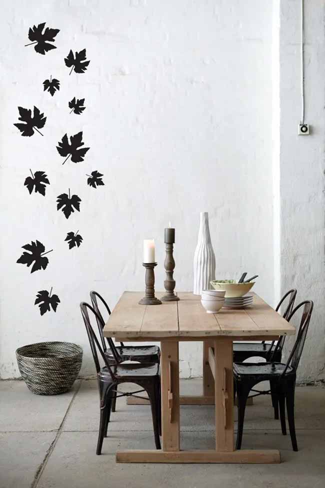 Wall Leaf Stickers. The big black leaf stickers that look like they are floating up the white wall are a clever, modern idea for fall. This simple dining area feels rustic with the light wood table and classic metal chairs.