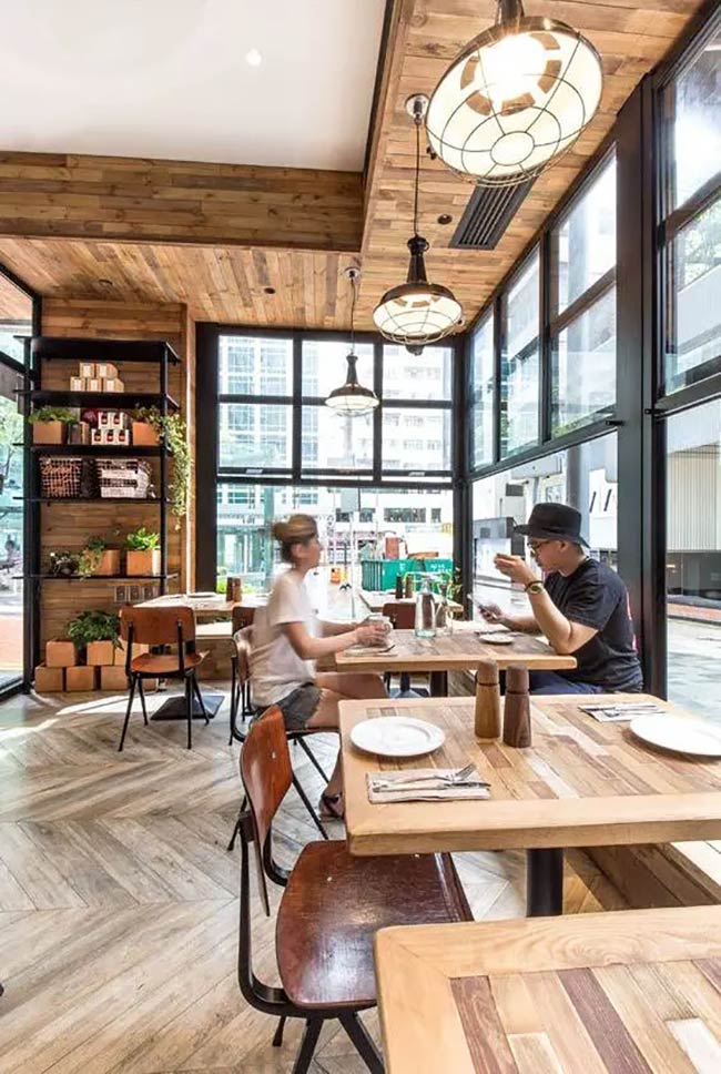 Wood is used everywhere here, from the paneled ceiling down to the beautiful herringbone floor. Big glass globe lights hang low to make the corner table look like the best and brightest seat in the house.