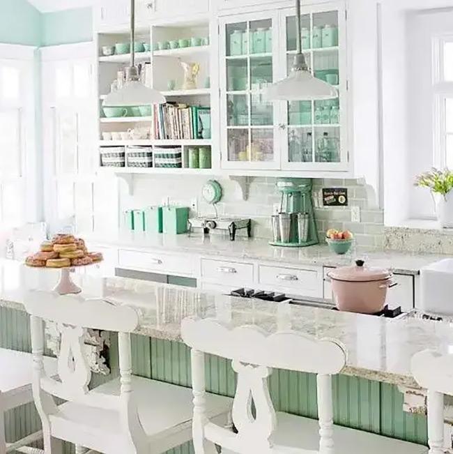 Some shelves are completely open, while others have glass fronts to keep dust away. The mint green paint on the back of the cabinets is a sweet surprise behind the dishes.