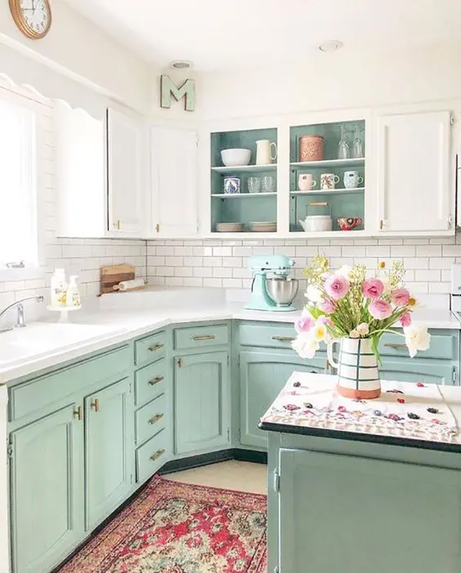 These mint green cabinets are so cheerful and bright. Leaving the doors off the corner upper cabinet lets you see the cute mugs and jars inside. It adds to the relaxed, cottage feel of the kitchen.