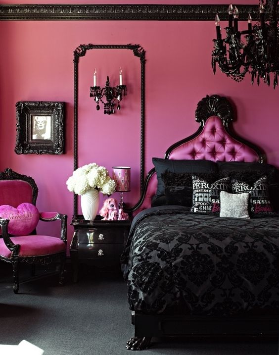 Hot pink walls make a huge statement behind the shiny black furniture. The ornate headboard and unique pillows create a very bold, glam style in this pink and black bedroom.