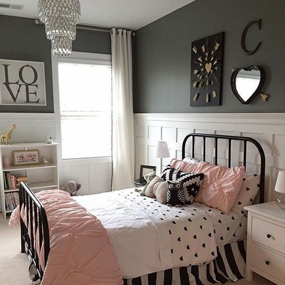 White wood paneling on the lower wall keeps the room feeling bright. The black metal bed looks very sweet with the heart mirror and arrow wall art. This is a charming idea for a pink and black bedroom.