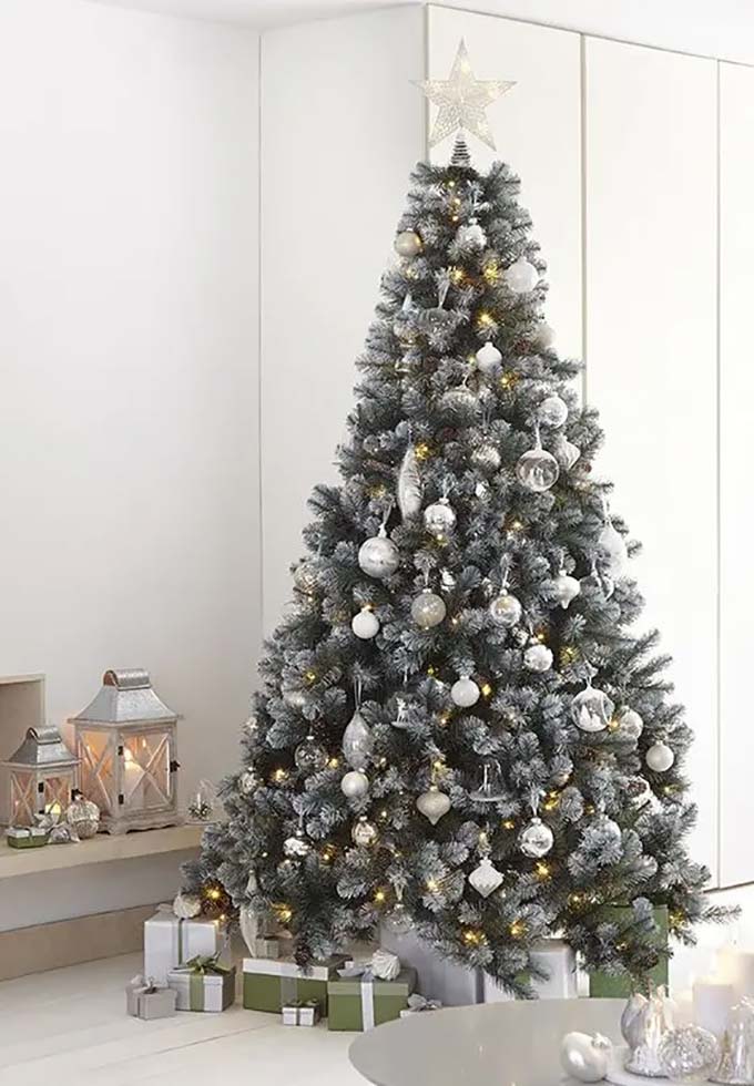 This snowy tree has a very clean and simple look. The pretty silver and white ornaments match the star on top and the presents on the floor.