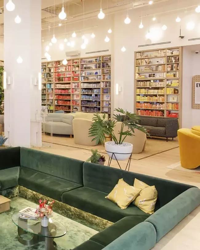 That dark green velvet sofa looks very soft. This conversation pit is in a big, open room, maybe a library, with all those bookshelves in the back.