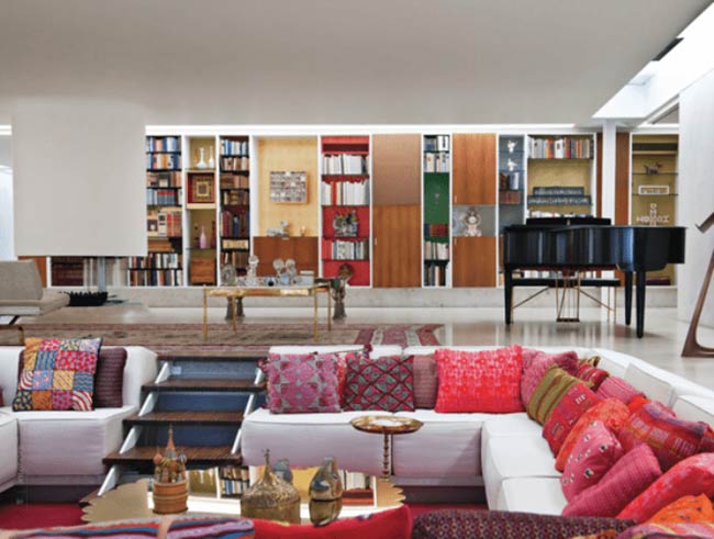 This room has so many colors! The white sofa in the conversation pit is covered in bright pink and red pillows.